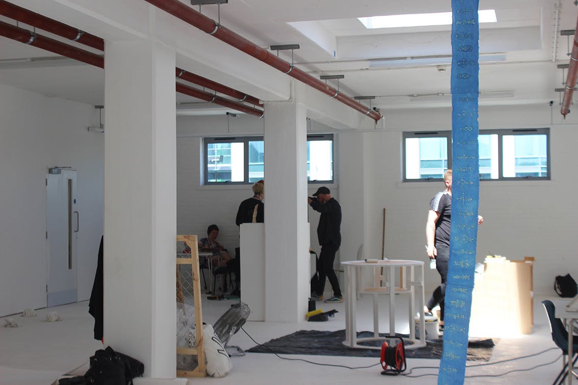 Students set up an exhibition in a white room with large pillars Testspace at Karst June 2021 Photos by Eloise Dodsworth