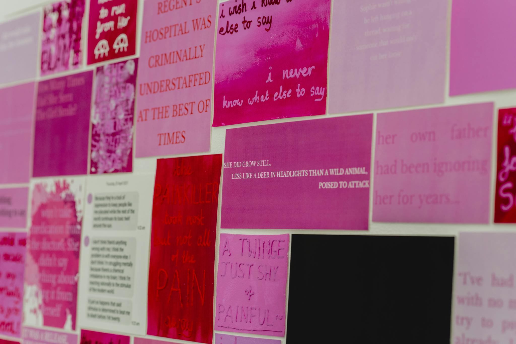 Image shows a wall featuring a number of pink images and quotes